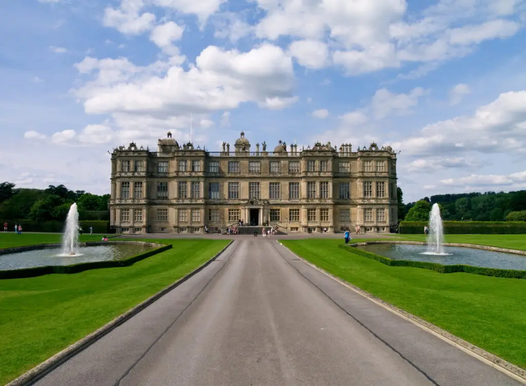 Longleat House and Gardens, a magnificent example of Elizabethan architecture in England, featuring vibrantly landscaped grounds and ornamental water fountains.