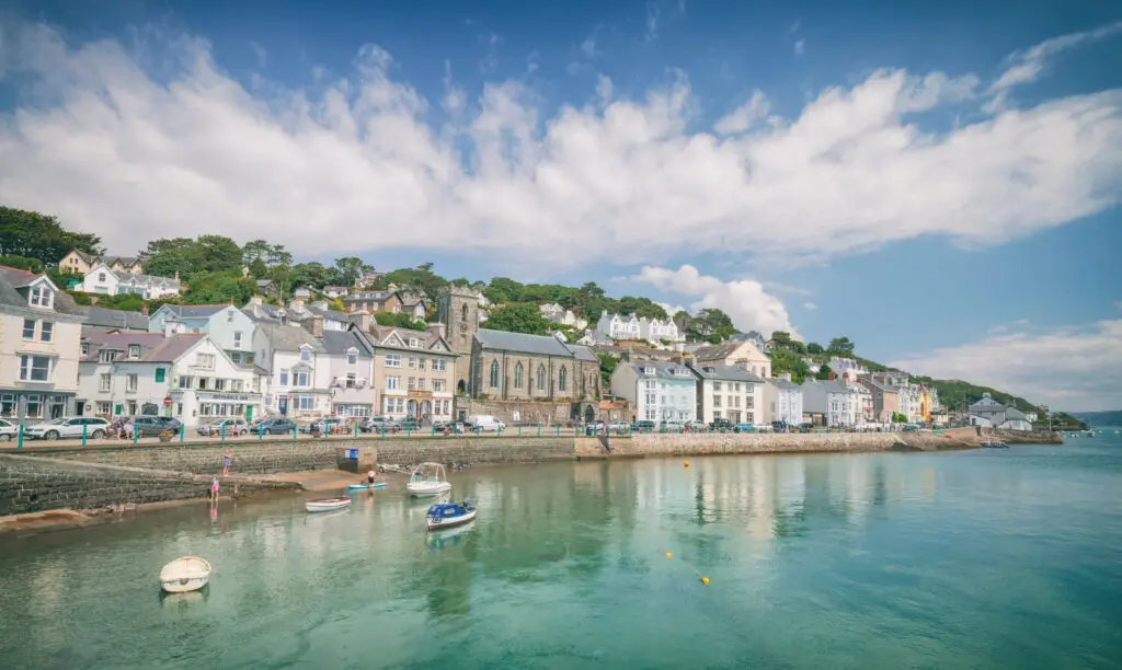 Scenic view of Aberdyfi, a coastal town in Wales, featuring colorful buildings, calm sea waters and a sunny sky, perfect for tourism and travel in the UK.