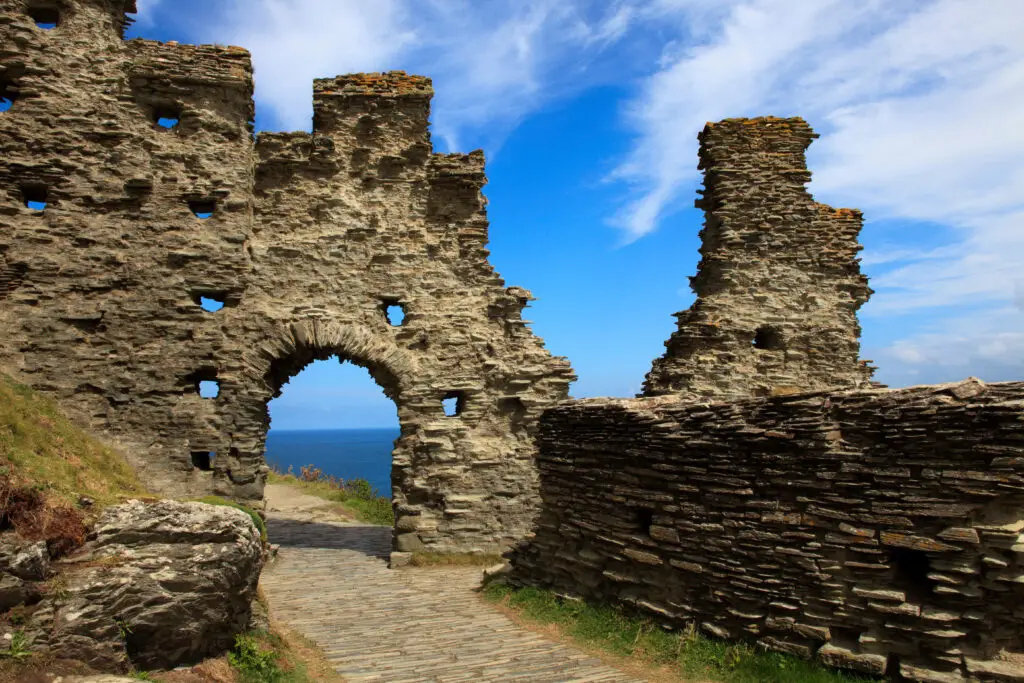 Historic Tintagel Castle ruins with picturesque archway overlooking the Cornish coast, England, UK.